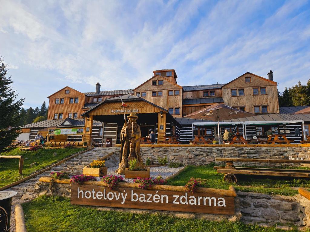 a hotel with a statue in front of a building at Horský hotel Kolínská bouda in Pec pod Sněžkou