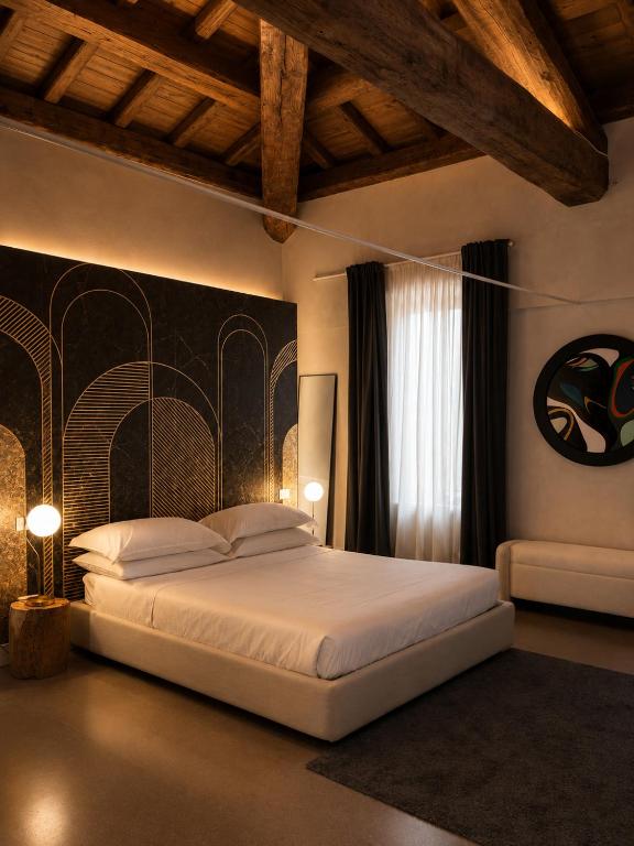 a bedroom with a large white bed in a room at Albergo Diffuso Ginevra Boutique Rooms - Palazzo Leosini - Residenze D'Epoca in LʼAquila