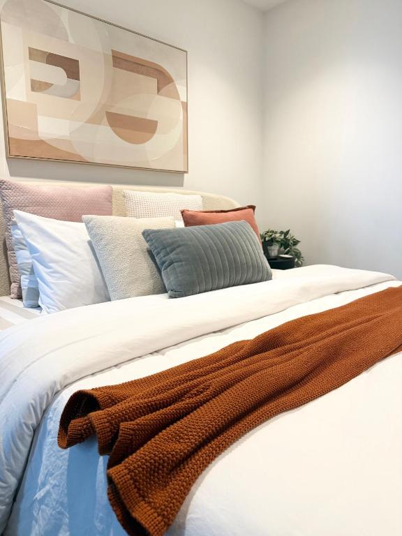 a bed with a brown blanket on top of it at CBD Apartment, Sleeps 4 with Free Car Park in Melbourne