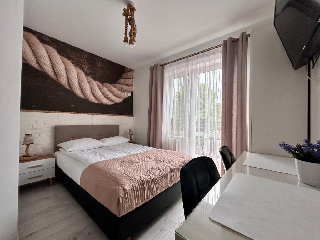 a bedroom with a bed and a table and a window at Perełka Bałtyku in Władysławowo