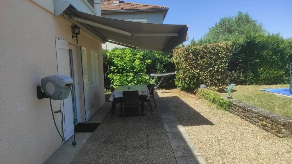 a patio with a table and an umbrella at Convivialetzen in Châtenoy-le-Royal