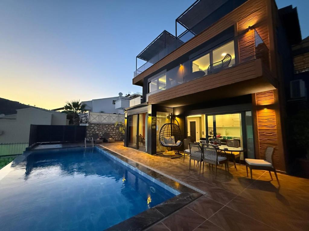 a house with a swimming pool in front of a house at Villa Elmas in Kalkan