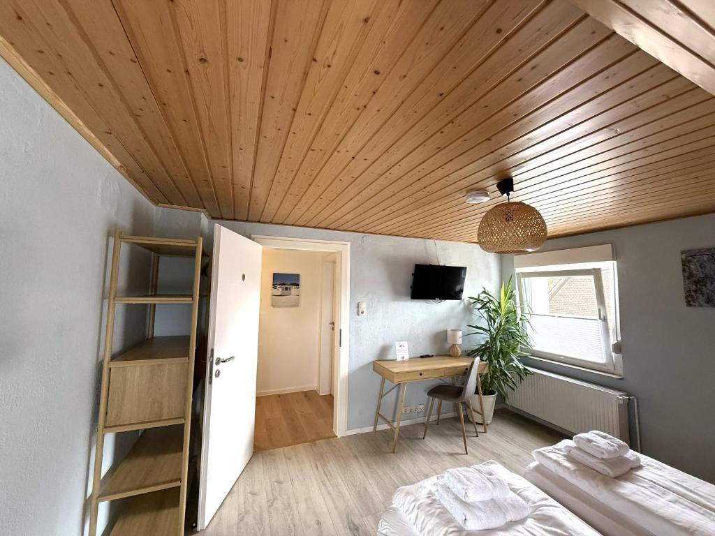 a room with a bed and a desk and a wooden ceiling at Gästewohnung in Algermissen in Algermissen