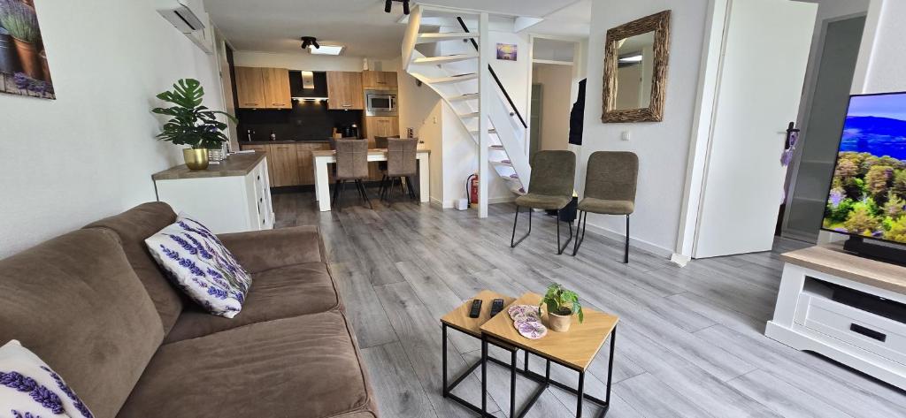 a living room with a couch and a table at Het lila huisje in Herkingen
