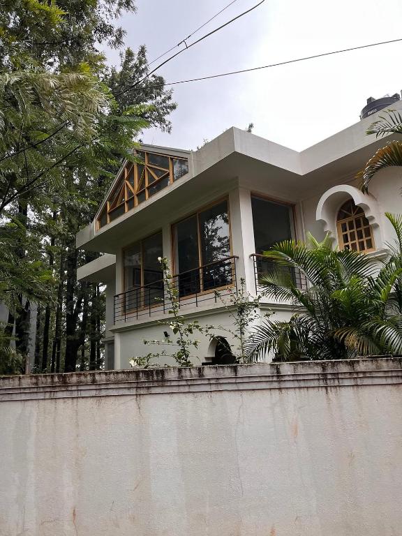 a house with a fence in front of it at Nature Trinity House in Panchgani