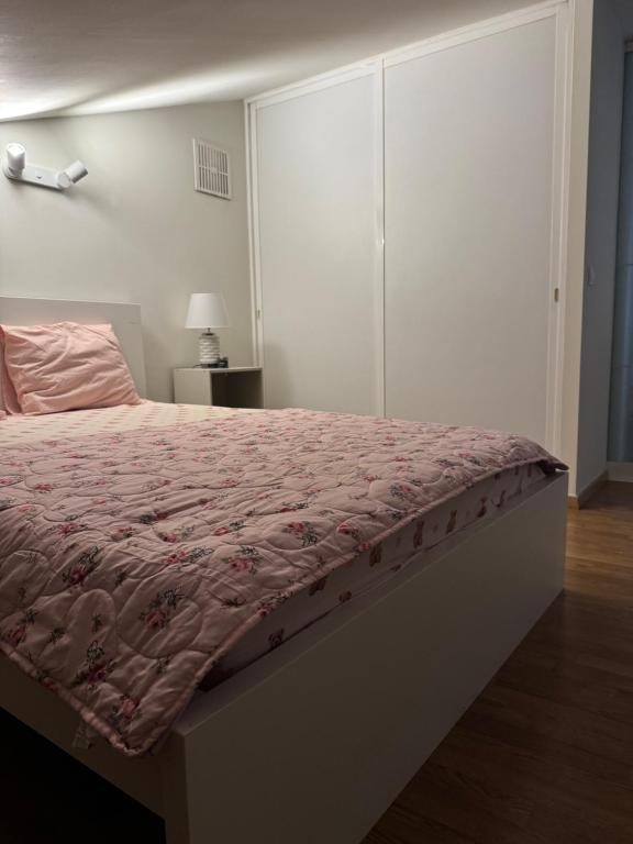 a bedroom with a bed with a pink comforter at Aroeira Elite Apartments in Aroeira