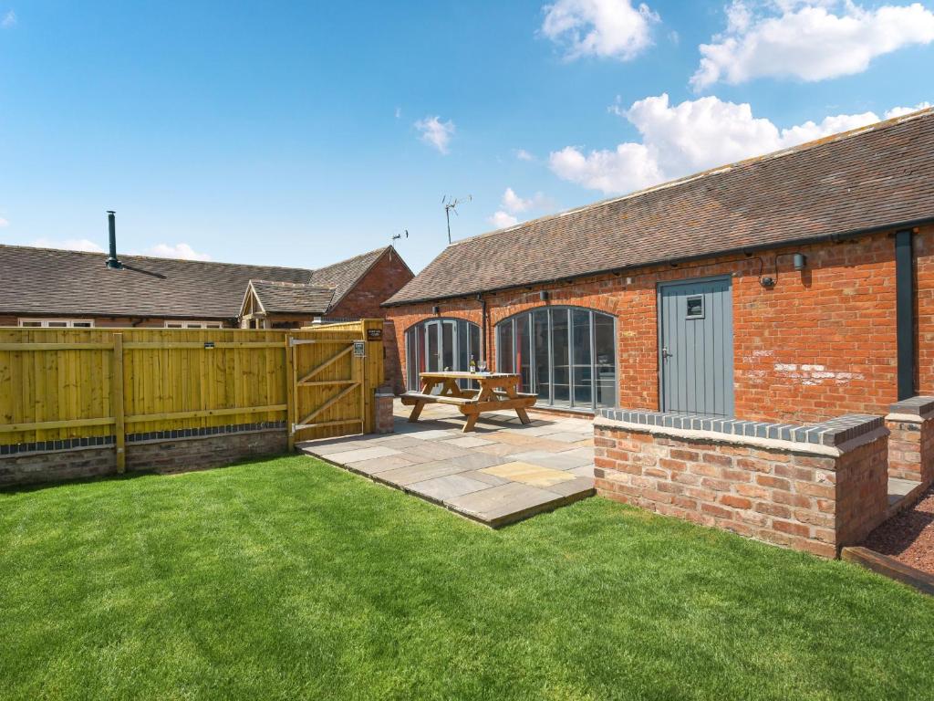 a backyard with a wooden fence and a picnic table at Cart House Barn - Uk49802 in Morville