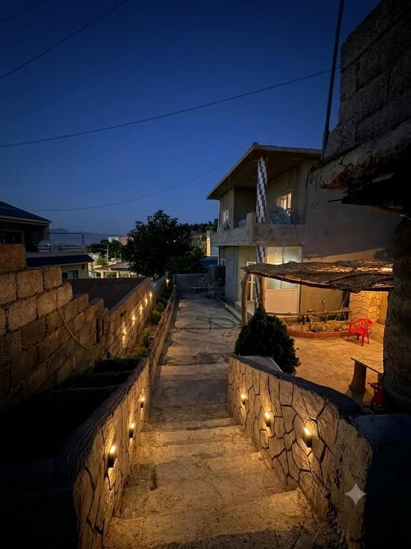 a stone wall with lights on the side of a building at Welcoming Multi-Bedroom House in Duhok