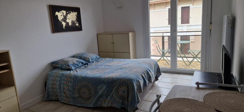 a bedroom with a bed and a large window at Studio moderne Évian, lac et therme in Évian-les-Bains