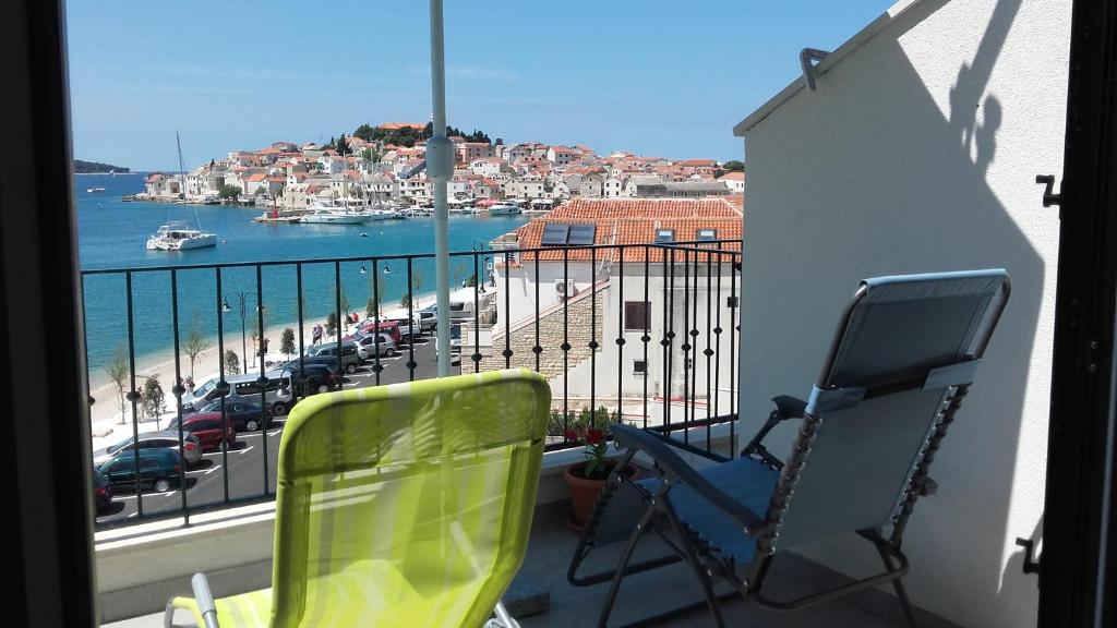 a balcony with two chairs and a view of a harbor at Villa Šiša in Primošten