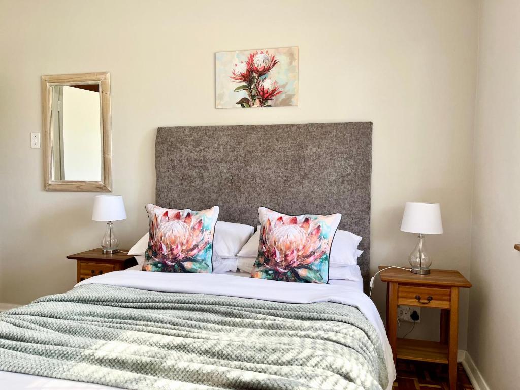 a bedroom with a large bed with two night stands at Karoo Velvet in Beaufort West