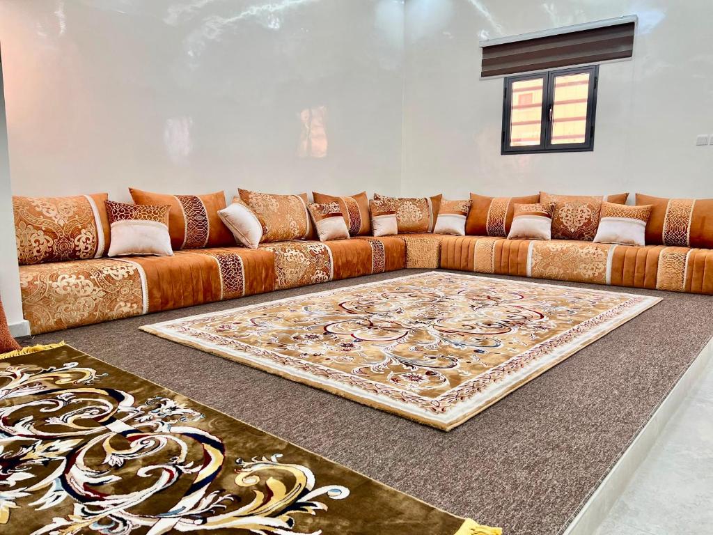 a living room with a brown couch and a rug at Midtown Appart Hôtel in Nouadhibou