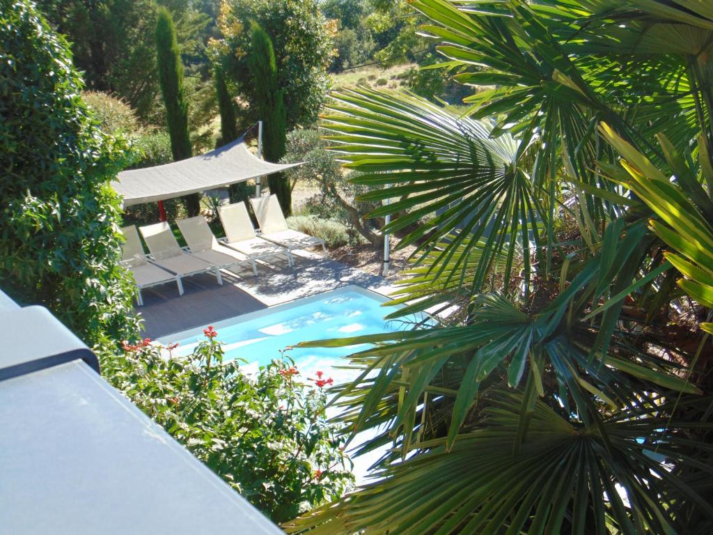 a swimming pool with a gazebo and a palm tree at Maison d'Hotes Les Palmiers in Gluiras