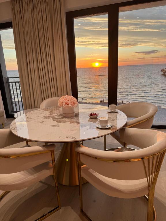 a table and chairs with a view of the ocean at Baltic Infinity Resort&Spa Apartament Dworek in Międzyzdroje