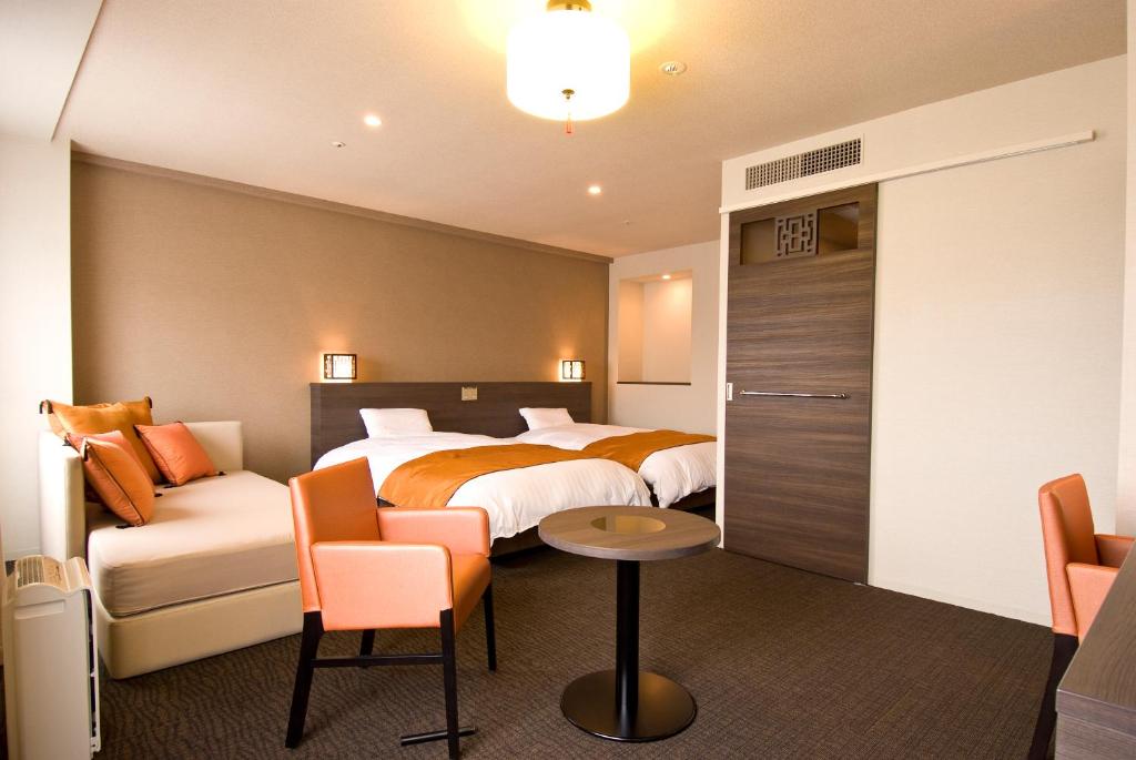 a hotel room with a bed and a couch at Dormy Inn Nagasaki Shinchichukagai in Nagasaki