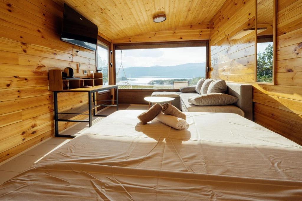 a bedroom with a large bed and a large window at Lenka & Anika in Nikšić