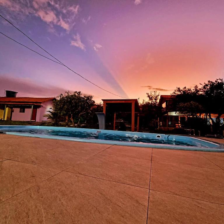 a rainbow in the sky over a swimming pool at Pousada Don Melo in Salvaterra