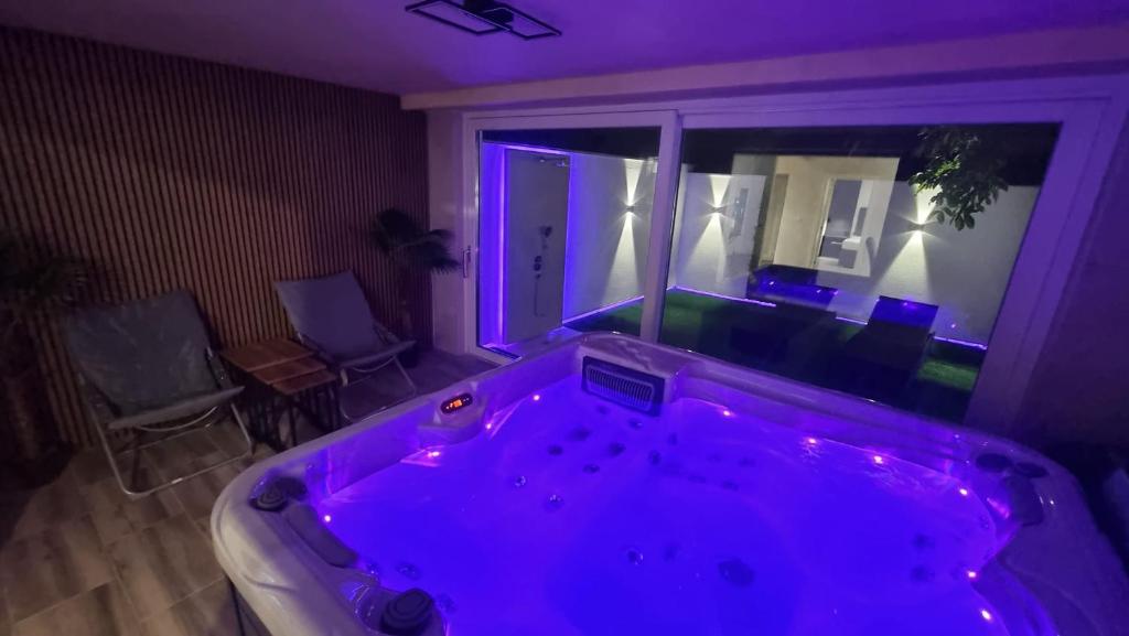 a large tub in a room with purple lighting at Jacuzzi apartments Istočno Sarajevo in Sarajevo