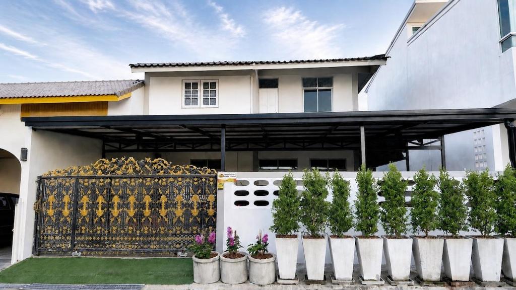 a white house with a fence and plants at Triple T House in Hat Yai