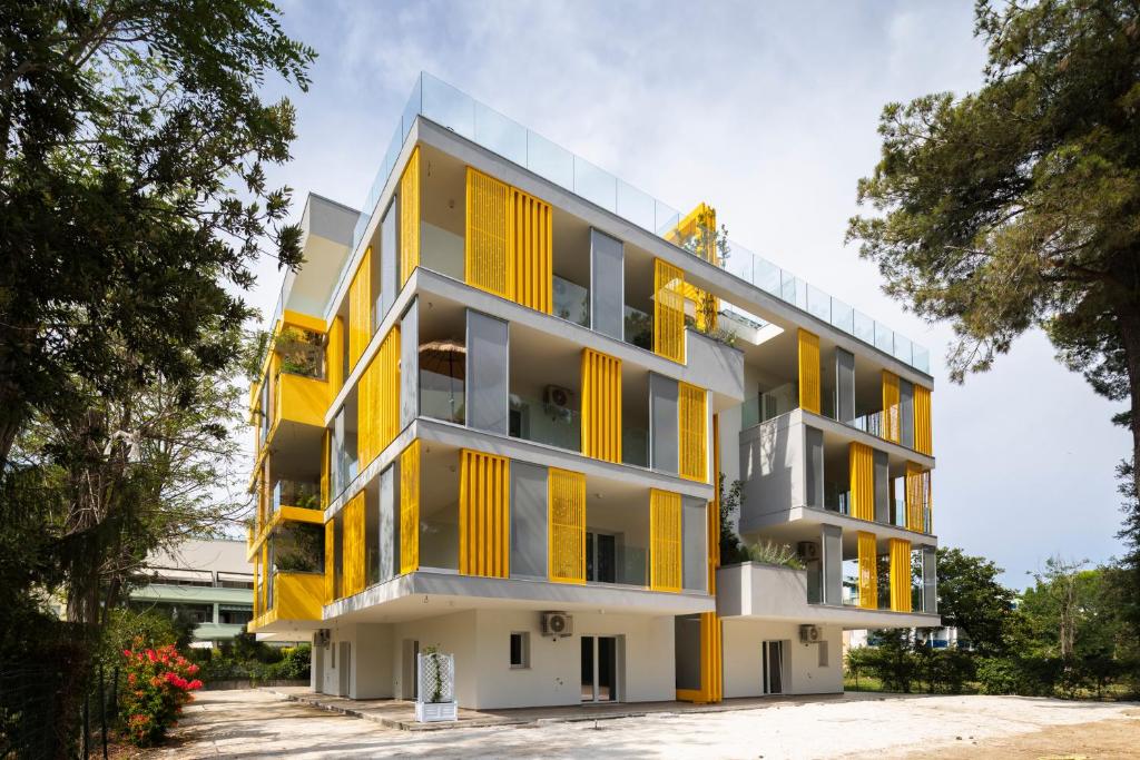 an apartment building with yellow windows at Don Cesar Palace in Bibione
