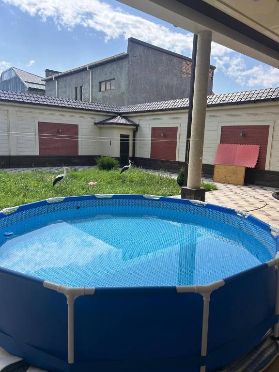 a large blue swimming pool in front of a house at Эксклюзивный Дом Самарканда in Samarkand