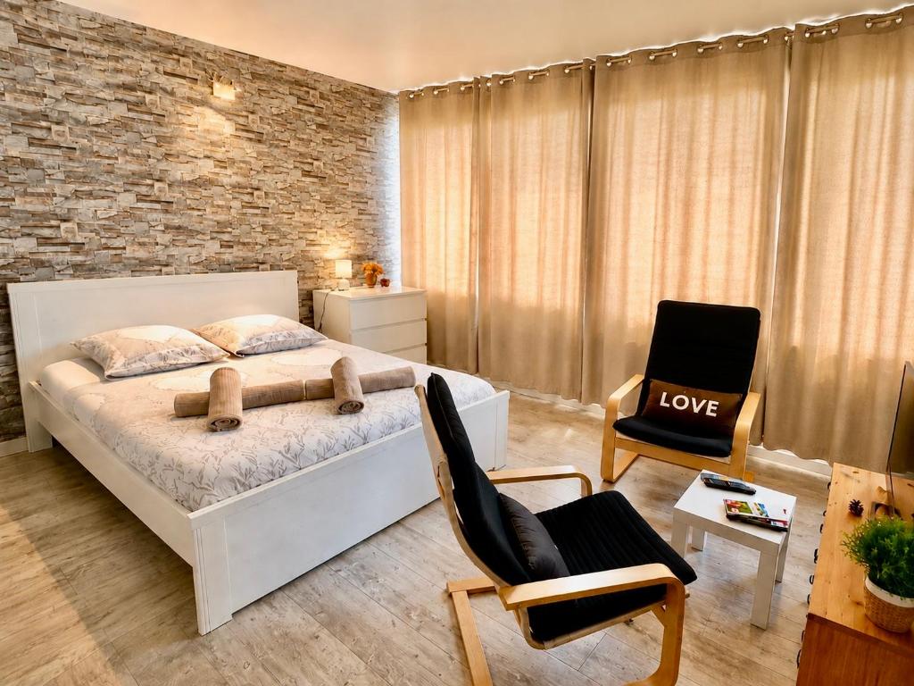a bedroom with a white bed and a brick wall at Petit Nid Nature Et Douceurs in Turckheim