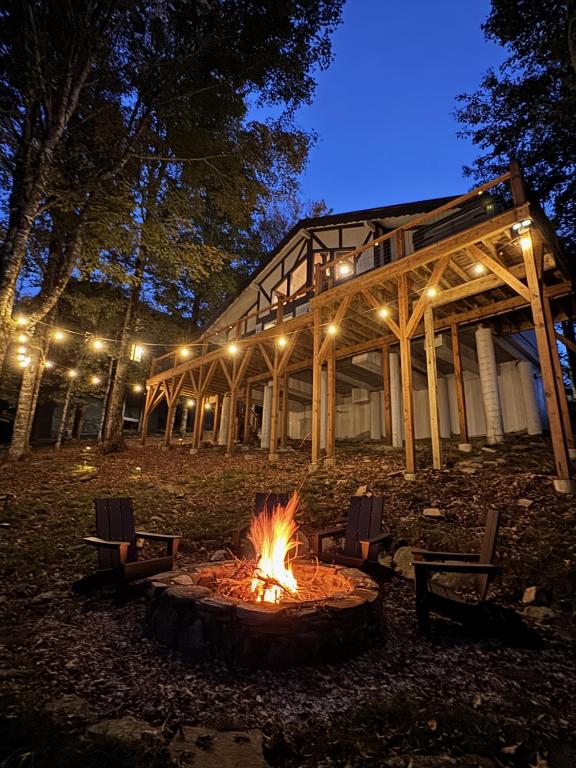 a fire pit in front of a building at night at Modern Chalet Hot Tub Game Loft 1 Mi to Skiing in Beech Mountain