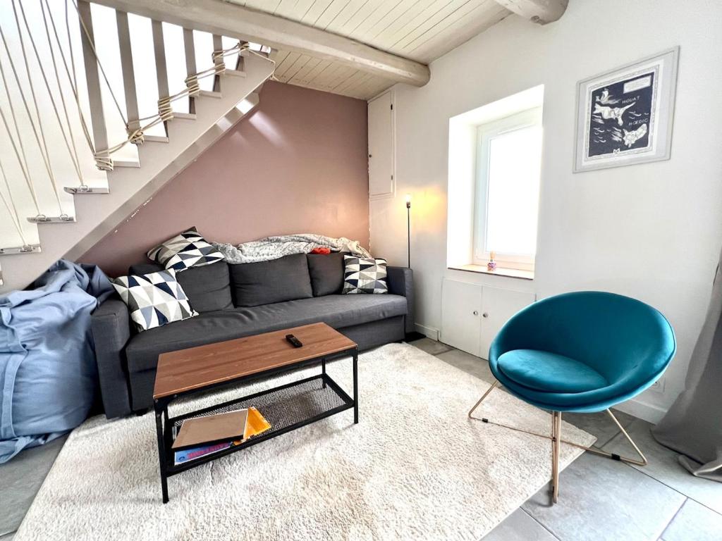 a living room with a couch and a blue chair at Maison de pêcheur Quiberon in Quiberon