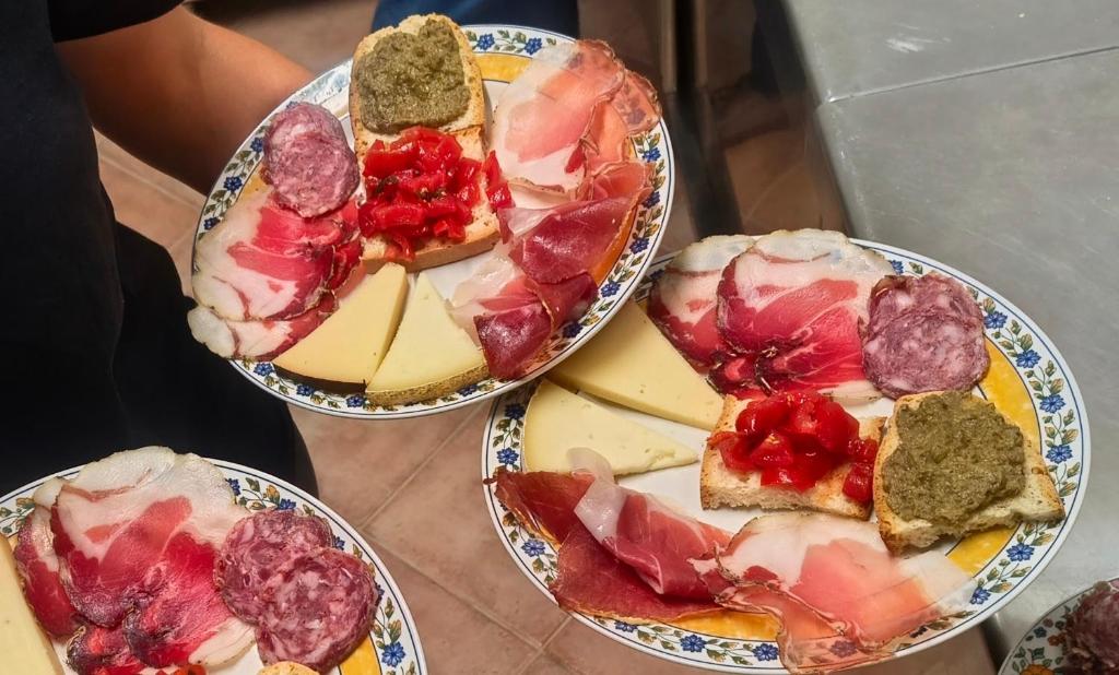 three plates of food with meat and cheese on them at Agriturismo Maremma Amara in Saturnia