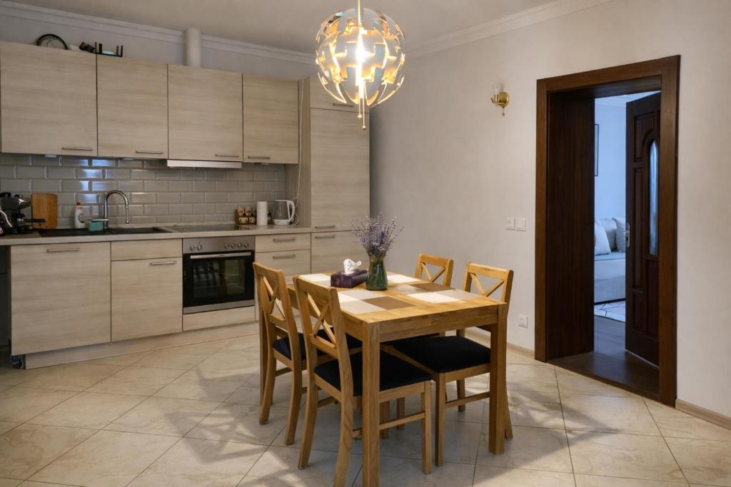 a kitchen with a wooden table with chairs and a chandelier at Woodside House in Solotvyno