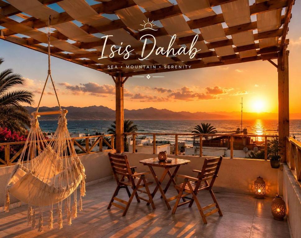 a patio with a hammock and a view of the ocean at Isis Dahab in Dahab