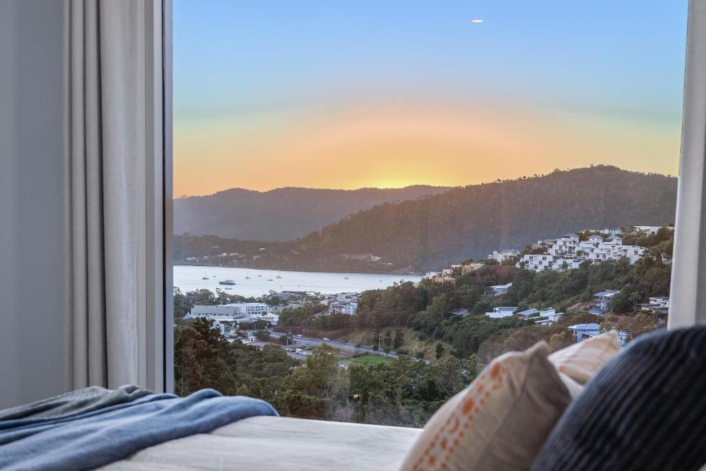a bedroom with a window with a view of the ocean at Seabreeze Lookout Azul in Airlie Beach