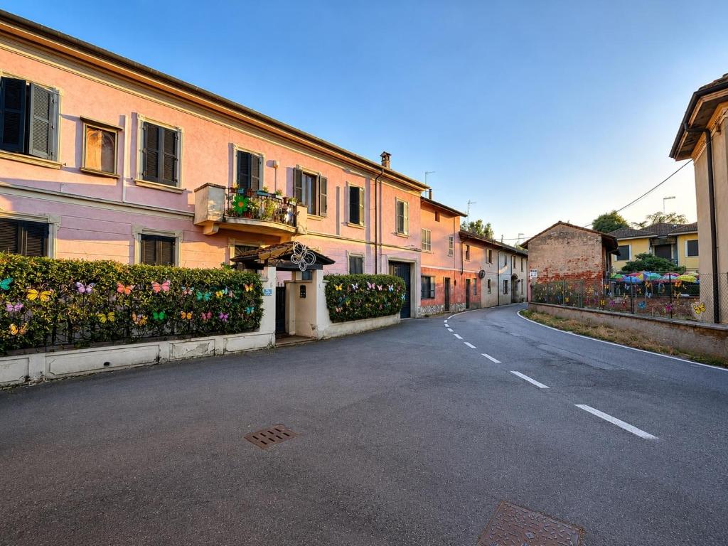 an empty street in a town with buildings and flowers at B&B La Borasca - Apartments in Casalpusterlengo