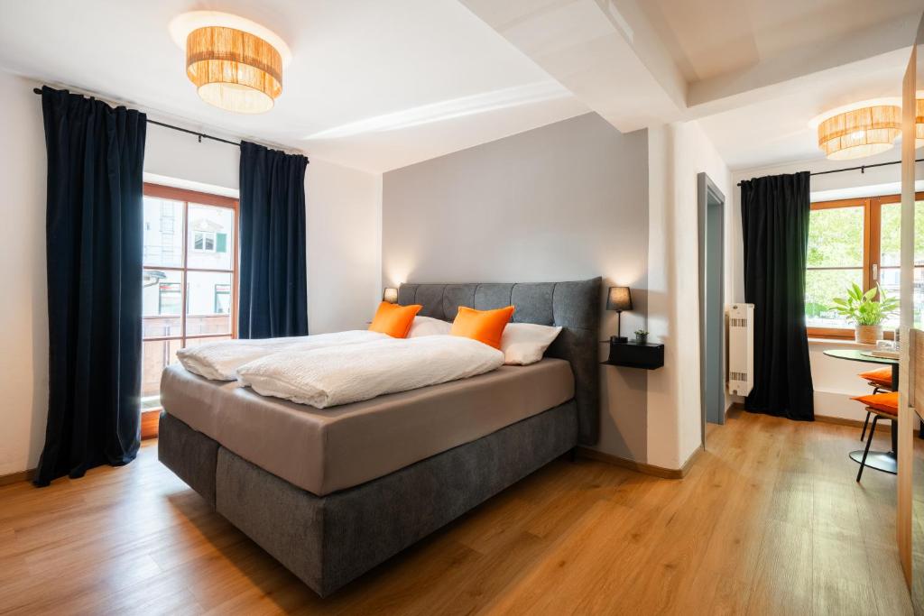 a bedroom with a large bed with orange pillows at Königslinde am Tegernsee in Bad Wiessee