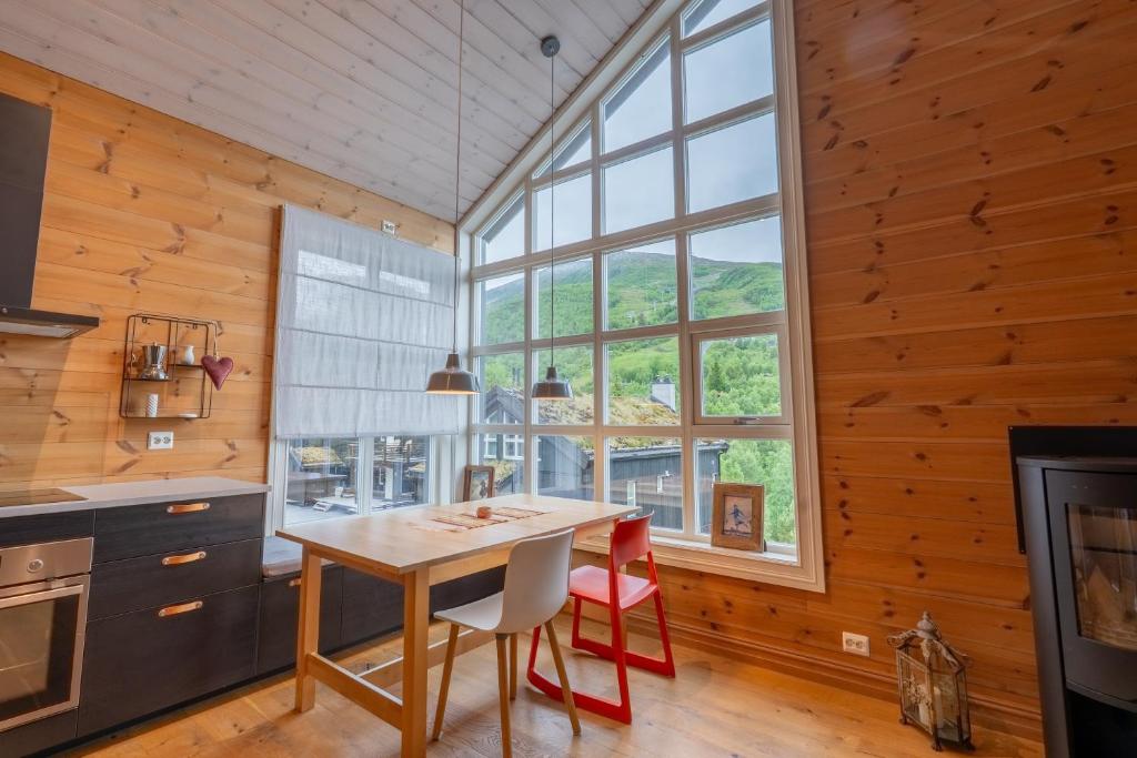 a kitchen with a table and chairs and a large window at Stranda Fjellgrend 36B in Stranda