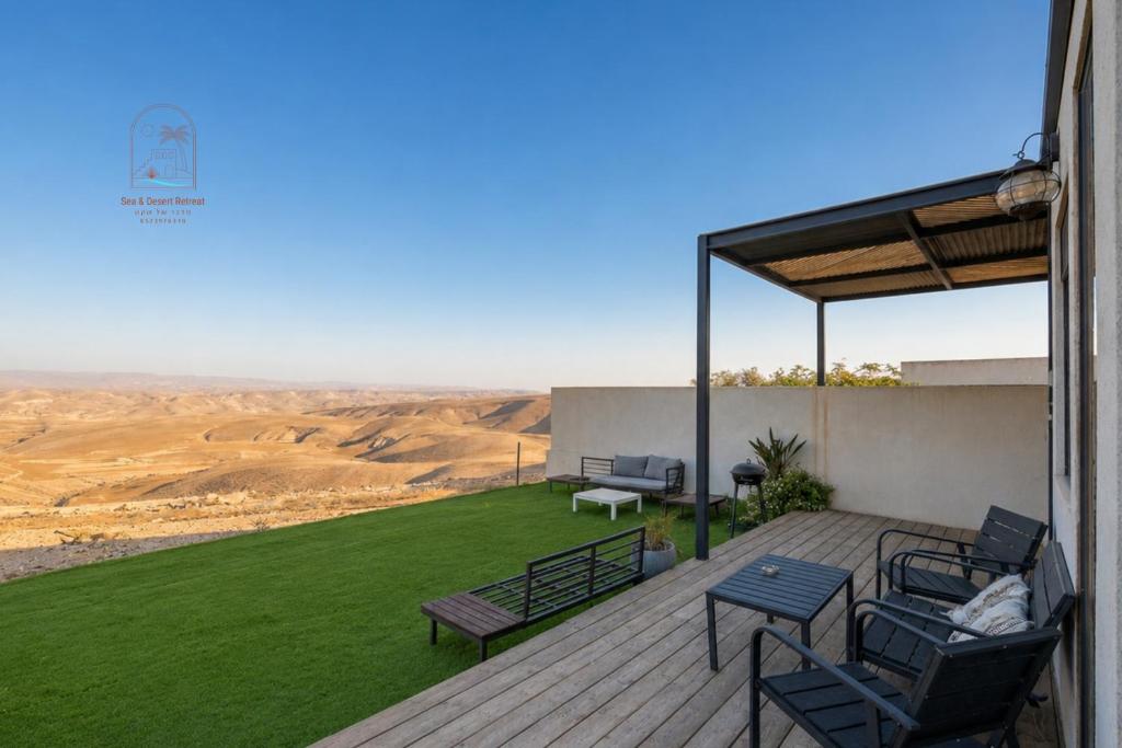 a deck with chairs and tables and a view of the desert at Sun, Mountain & Adventure in Arad