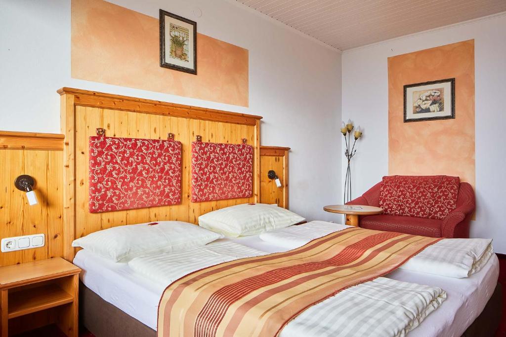a bedroom with a bed and a red chair at Eidenberger Alm in Eidenberg