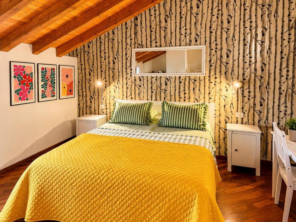 a bedroom with a bed with a yellow blanket at B&B La Borasca in Casalpusterlengo