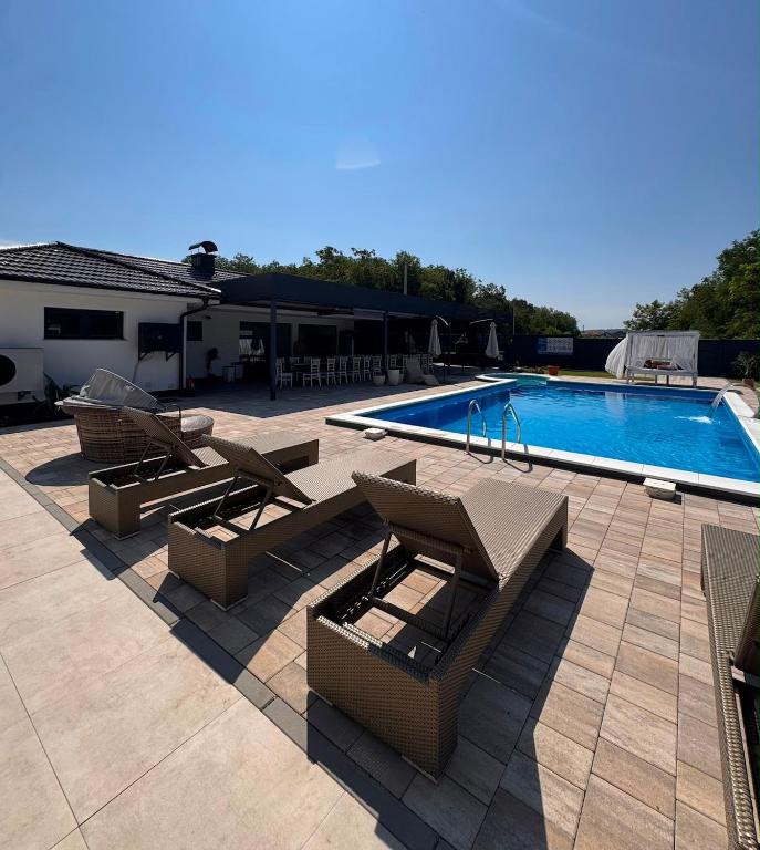 a swimming pool with lounge chairs and a swimming pool at Villa ZANS in Gradačac