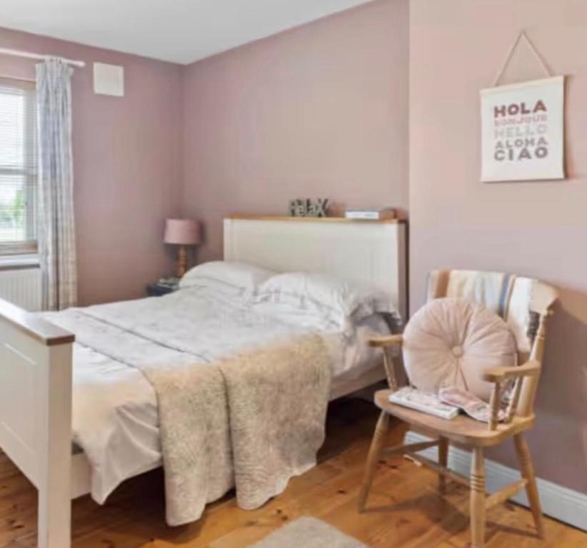 a bedroom with a white bed and a chair at Southeast Getaway in Limerick