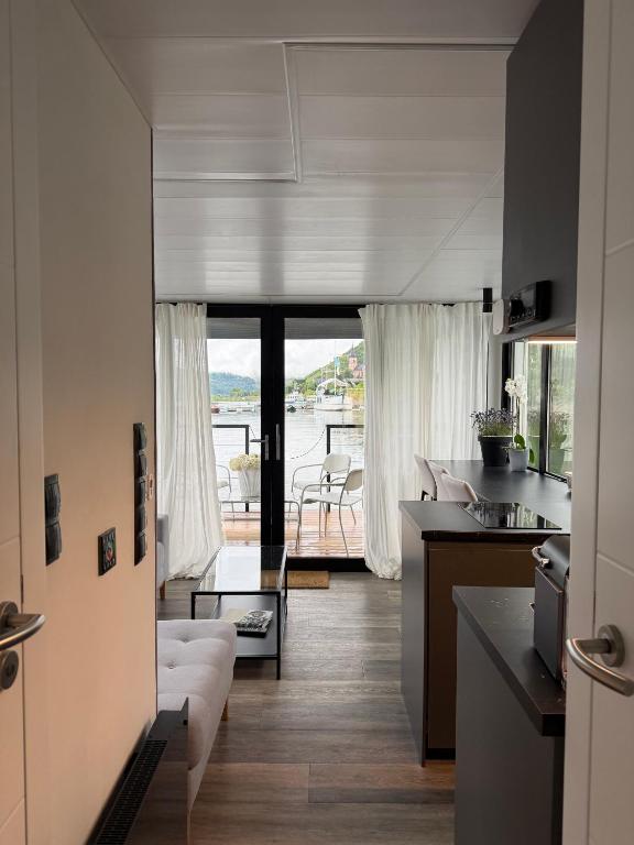 a kitchen and living room with a view of the water at Design-Hausboot am Rheinsteig in Lorch am Rhein