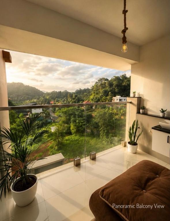 a large window in a living room with a view at Mirage 8D Inn in Vythiri