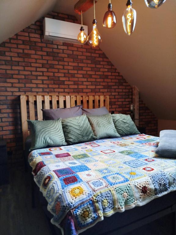 a bedroom with a bed with a quilt on it at Le fenil du Grand Dormeur - Chambres d'hôtes in Bischoffsheim