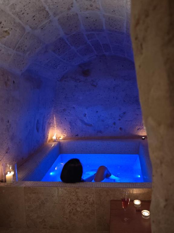 a person laying in a tub in a room with lights at Dimore dei Mercanti in Matera