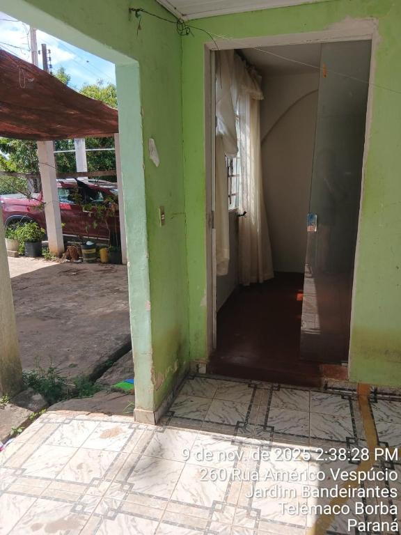 an open door of a house with a green wall at Pousada na Band Quarto 05 in Telêmaco Borba
