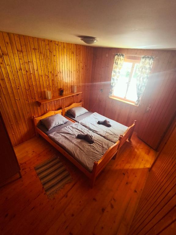 a bedroom with a large bed in a wooden room at Grizzly Krpáčovo in Dolná Lehota