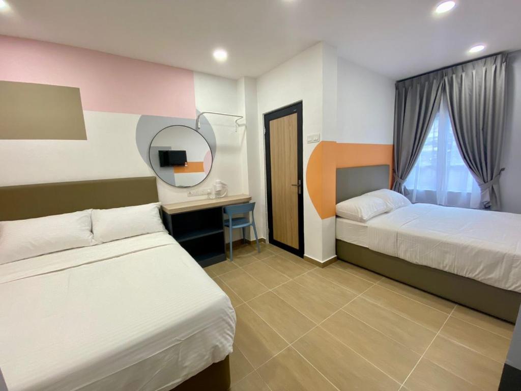 a hotel room with two beds and a mirror at Moon Hotel BRINCHANG Town in Brinchang