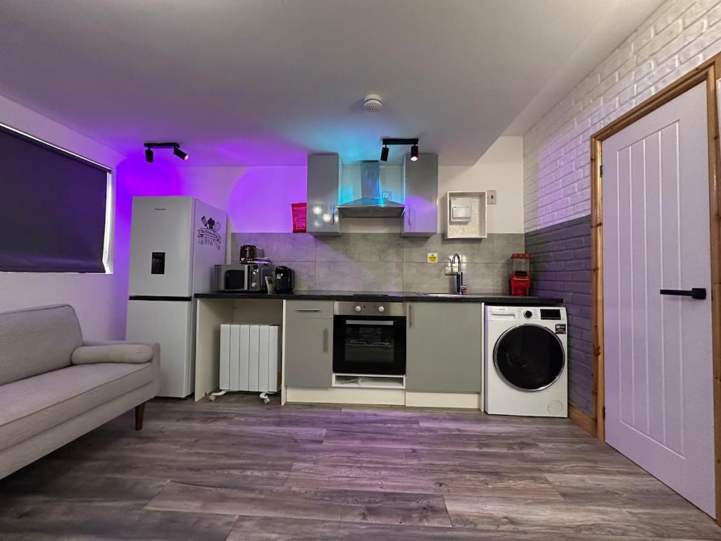 a kitchen with purple lighting and a washer and dryer at The Lofton A Loft Above the Rest in Headingley