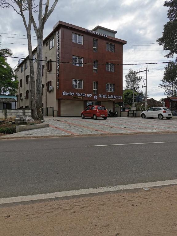 a red car parked in front of a building at Hotel Gateway Inn in Kushālnagar