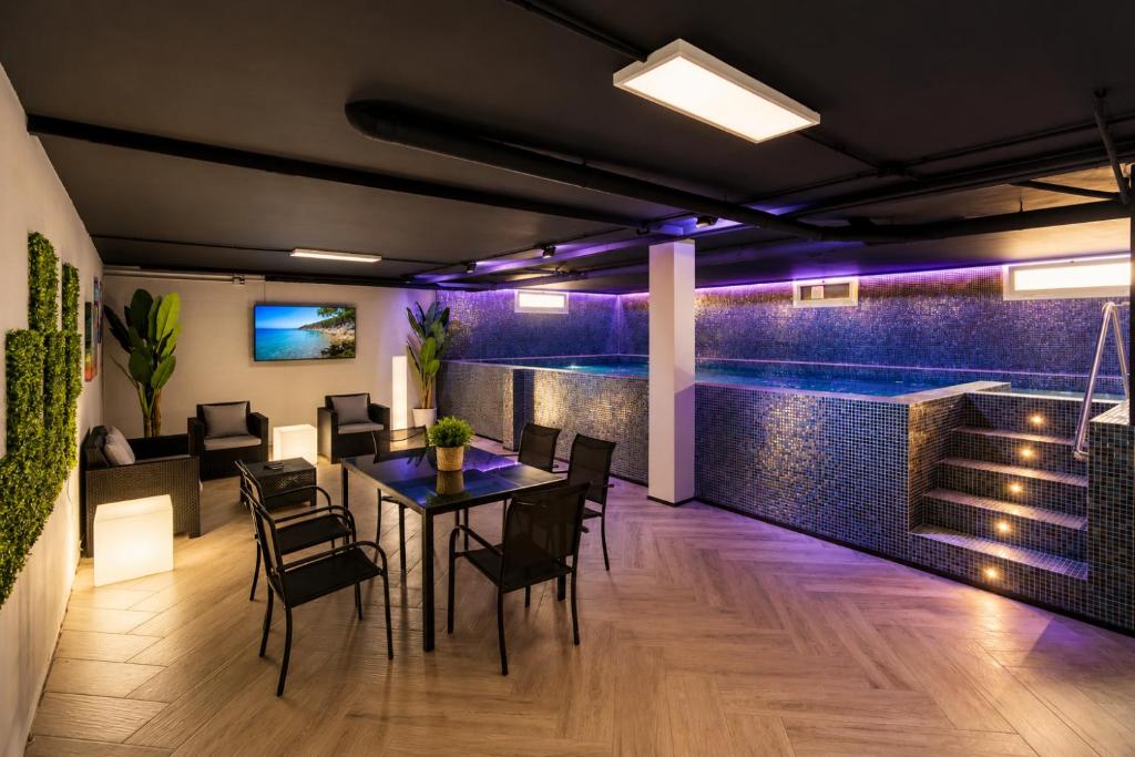 a room with a table and chairs and a swimming pool at Villa BARLOVENTO SPA in Cambrils